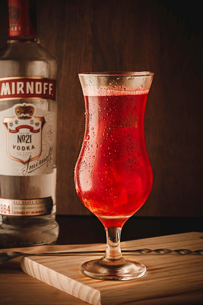 services-02 Chilled red cocktail in a glass with a vodka bottle backdrop, perfect for party themes.